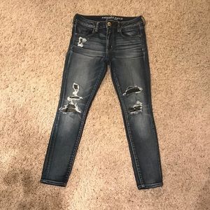American Eagle jeans with holes and black patches